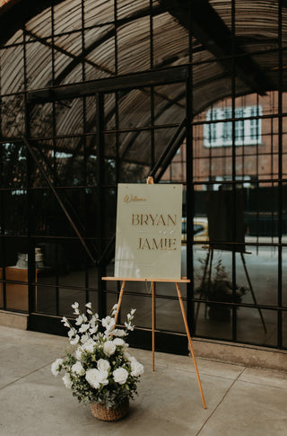 Easel with a sign reading 'Bryan & Jamie' in front of a large glass door.